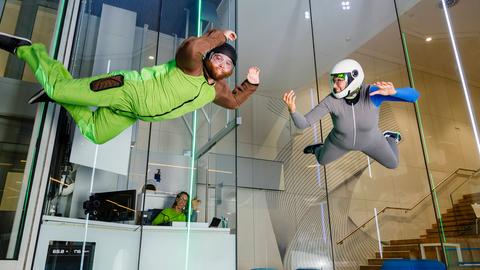 Indoor Skydiving, eine Frau und ein Mann fliegen in der Luft