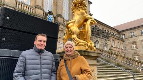 Der Stadtdezernent und die Kassel-Marketing-Sprecherin stehen vor einem großen Subwoofer direkt vor dem Kasseler Rathaus.