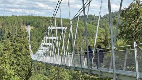 Menschen laufen über die Hängebrücke in Willingen