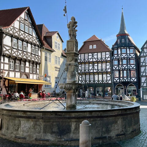 Der Rolandsbrunnen auf dem mittelalterlichen Marktplatz. Im Hintergrund sind Fachwerkhäuser zu sehen.