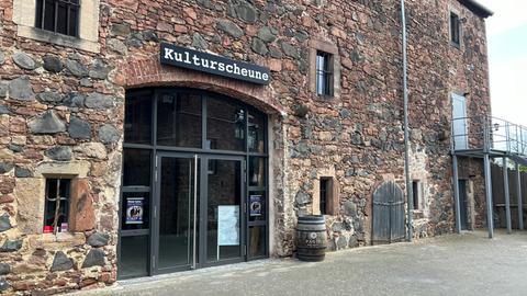 Alte Mauern, moderner Inhalt: Blick auf die Kulturscheune in Fritzlar. Über dem Eingang hängt ein Schild mit dem Schild "Kulturscheune".