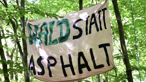 Ein Plakat mit der Aufschrift "Wald statt Asphalt".