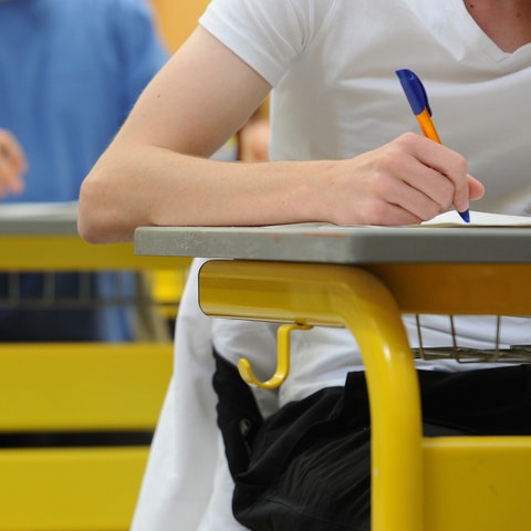 Schüler schreibt an einem Tisch