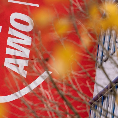 Geschäftsstelle der Arbeiterwohlfahrt (AWO) in Frankfurt mit dem AWO-Logo hinter Zweigen eines Baumes