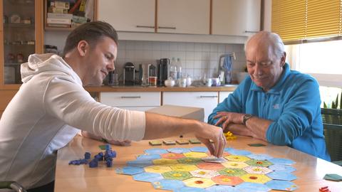 Spiele-Erfinder Klaus Teuber (rechts) spielt mit seinem Sohn das Spiel Catan