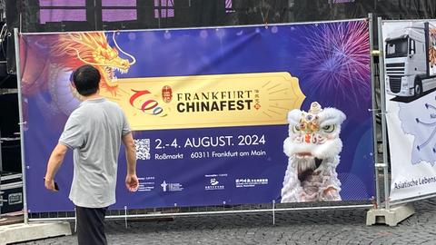 Plakat mit einem Drachen vor einer Bühne beim China-Fest in der Frankfurter Innenstadt