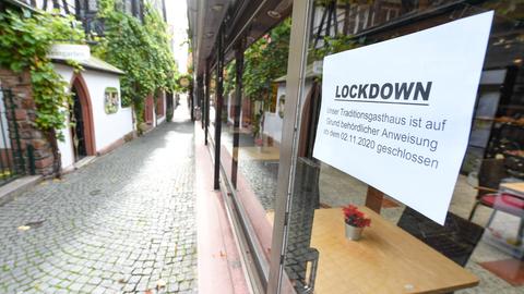 Eine geschlossene Gaststätte in Rüdesheim am Rhein. Auf einem Schild in der Fensterscheibe steht: "Lockdown. Unser Traditionsgasthaus ist auf Grund behördlicher Anweisung geschlossen."