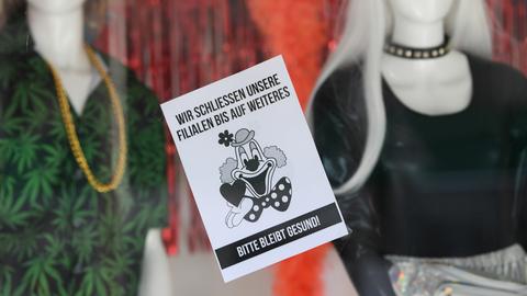 Ein Schild mit der Aufschrift "Wir schließen unsere Filialen bis auf Weiteres. Bitte bleibt gesund" an einem Frankfurt Texilgeschäft. 