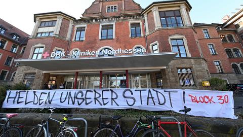 „Helden unserer Stadt“ steht auf einem Banner vor den DRK-Kliniken Nordhessen, das von der Fangruppe Block 30 des Fußballvereins KSV Hessen Kassel vor dem Eingang aufgehängt wurde. Wegen der Corona-Krise gilt ein weitgehendes Kontaktverbot für Hessen. Es dürfen zur noch maximal zwei Personen gemeinsam nach draußen gehen.