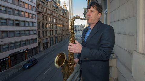 Der Saxophonist Tobias Rüger spielt von einem Balkon in Frankfurt. Vielerorts in Hessen beteiligten sich am Sonntag, dem 22. März um 18 Uhr Menschen an dem bundesweiten Flashmob "Götterfunken am Fenster“. Musiker spielten dabei Beethovens Schlusschoral "Freude schöner Götterfunken". Der hessische Musikerverband hatte auf Facebook Text und Noten bereitgestellt. Als Zeichen der Solidarität in Zeiten von Corona unterstützen wir den Flashmob", hieß es.