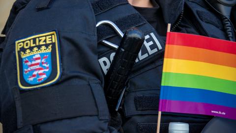 Bild von der Parade des CSD - Polizistin hält Regenbogen-Flagge.