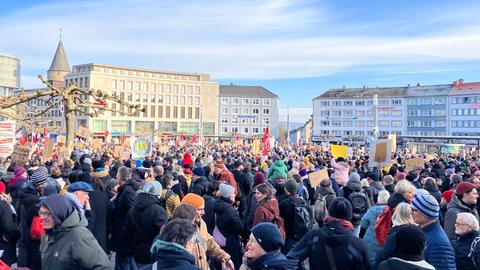 Menschenmenge mit Plakaten auf einem großen Platz