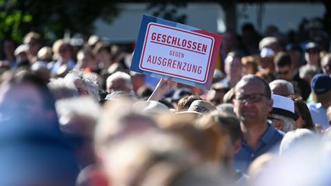 Menschenmenge demonstriet, einer hält Schild "Geschlossen gegen Ausgrenzung"