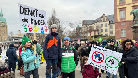 Eltern halten gemeinsam mit ihren Kindern Demo-Plakate fest.