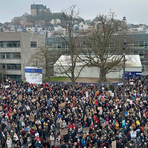 Menschentraube in Marburg mit Plakaten.