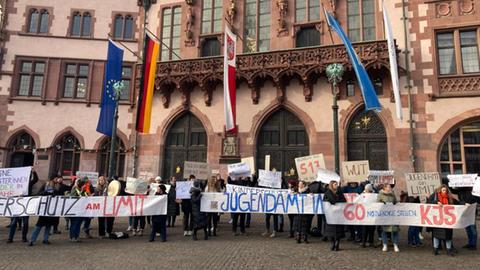 Menschen mit Plakaten haben sich vor dem Römer aufgestellt. Auf den Plakaten steht: "Wut", "Jugendamt am Limit", "Kinderschutz am Limit".