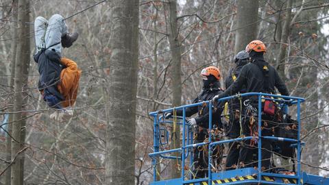 Ein Demonstrant hängt im Dannenröder Forst kopfüber an einer Traverse.