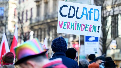 "CDUAFD verhindern" steht auf einem selbstgebastelten Plakat, das ein von anderen Demonstranten umgebener Demonstrant hochhält