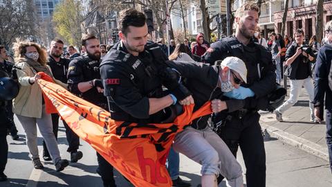 Polizisten führen einen Demonstranten ab