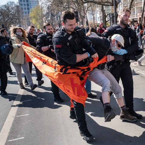 Polizisten führen einen Demonstranten ab