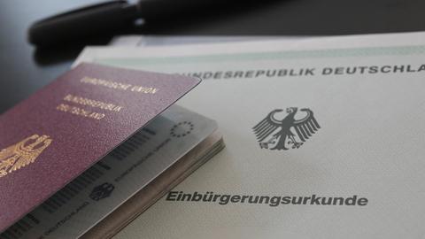 Ein deutscher Reisepass und eine Einbürgerungsurkunde liegen auf einem Tisch