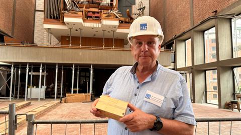 Ein Mann mit Helm und Holzblock in der Hand steht in der Elisabethkirche