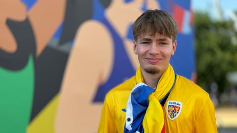 Fanzone am Main: Ein junger Mann im Rumänien-Trikot lächelt in die Kamera