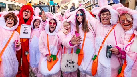 Mehrere Frauen im rosa Kaninchen-Kostüm postieren lachend für die Kamera.