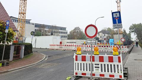 Viele Schilder auf einer Straße vor einer Baustelle.