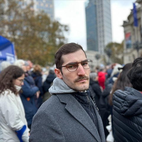 Der jüdische Student Daniel Navon steht vor einem Israel-Banner in der Frankfurter Innenstadt