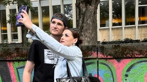 Alina und Dan machen ein Selfie-Video mit ihrem Smartphone