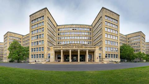 Foto mit einem Fischauge-Objektiv fotografiert: Außenansicht eines Uni-Gebäudes. Haupteingang mit Schriftzug "Johann Wolfgang Goethe-Universität Frankfurt" über dem Portal. 