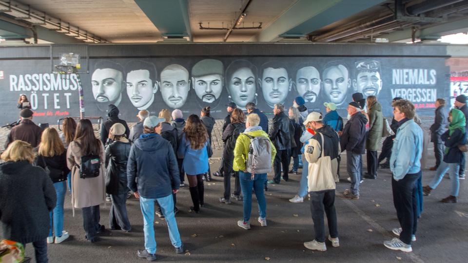 An der Friedensbrücke befindet sich das 27 Meter lange Graffito mit den Gesichtern der neun Menschen, die bei dem rassistischen Anschlag in Hanau vor mehr als viereinhalb Jahren ums Leben kamen