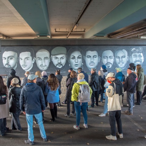 An der Friedensbrücke befindet sich das 27 Meter lange Graffito mit den Gesichtern der neun Menschen, die bei dem rassistischen Anschlag in Hanau vor mehr als viereinhalb Jahren ums Leben kamen