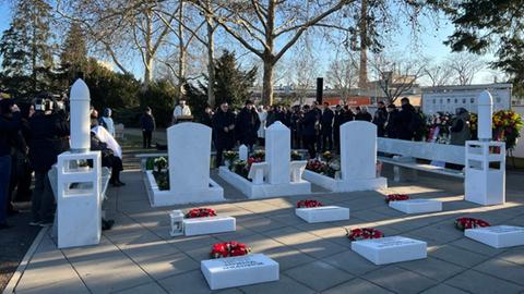 Menschen stehen auf Friedhof in Hanau