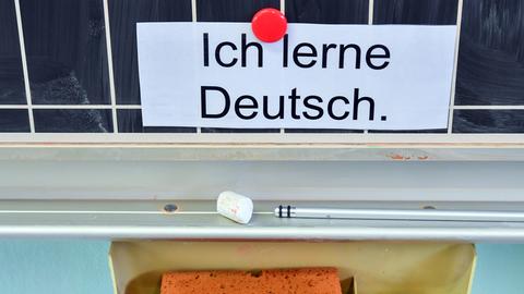 Zettel mit Aufschrift "Ich lerne Deutsch" an einer Tafel