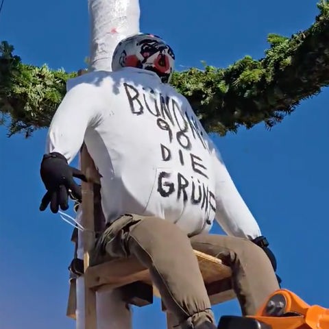 An einem Mast hängt eine Puppe mit der Aufschrift Bündnis 90 die Grünen