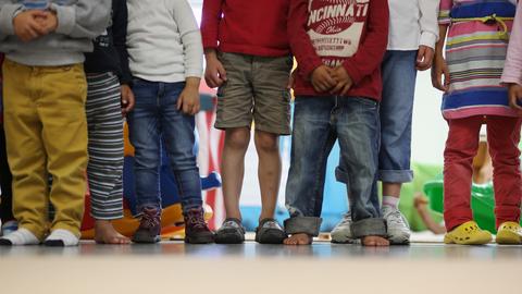 Kindergartenkinder stehen in einer Reihe eng zusammen