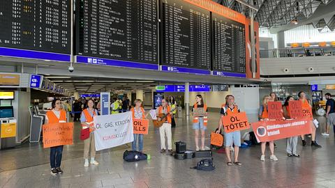 Aktivisten der "Letzten Generation" protestieren im Terminal eins des Frankfurter Flughafens.