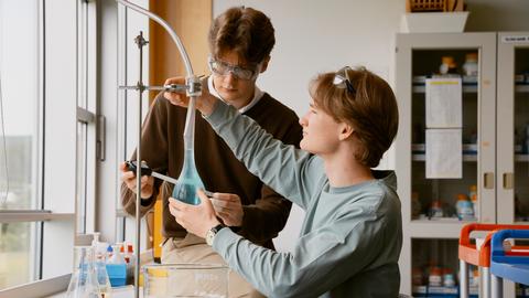 Zwei junge Männer in einem Labor an einer Apparatur.