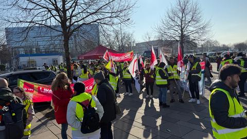 Dutzende Menschen mit Warnwesten und Verdi-Fahnen stehen versammelt