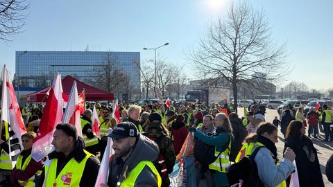 Dutzende Menschen mit Warnwesten und Verdi-Fahnen stehen versammelt.