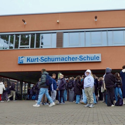 Außenaufnahme einer Schule, an dem Gebäude prangt ein Schriftzug "Kurt-Schumacher-SChule"