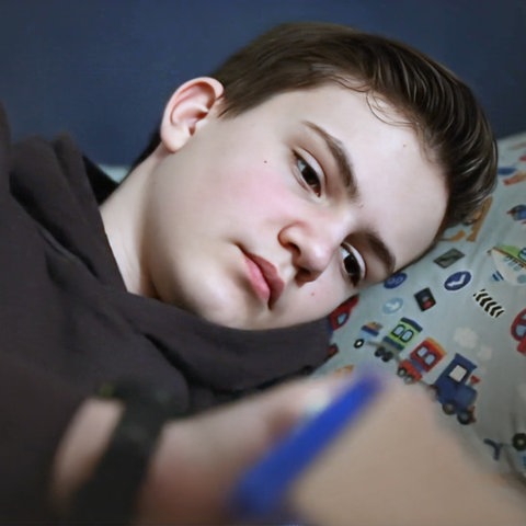 Nahaufnahme eines erschöpften Teenagers im Bett