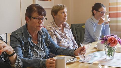 Vier Frauen sitzen beim Kaffee am Tisch