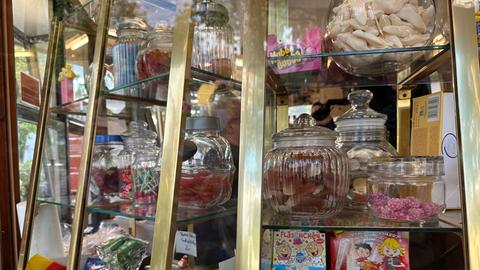 In der Auslage des Kiosk 1975 sieht man viele Gläser mit bunten Süßigkeiten.