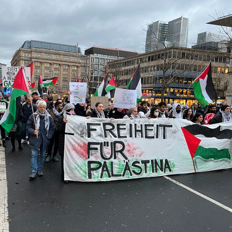 Teilnehmer einer Pro-Palästina-Demo am Tag vor Heiligabend in der Frankfurter Innenstadt mit Palästina-Flaggen und dem Spruchband "Freiheit für Palästina"