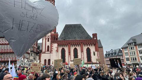 Demo-Teilnehmer mit Ballon mit Aufschrift "Herz statt Hetze" inmitten vieler Teilnehmenden