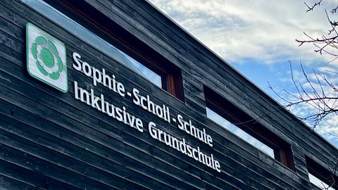 Holzfassade eines Gebäudes mit Schriftzug: Sophie-Scholl-Schule, Inklusive Grundschule 