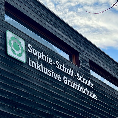 Holzfassade eines Gebäudes mit Schriftzug: Sophie-Scholl-Schule, Inklusive Grundschule 